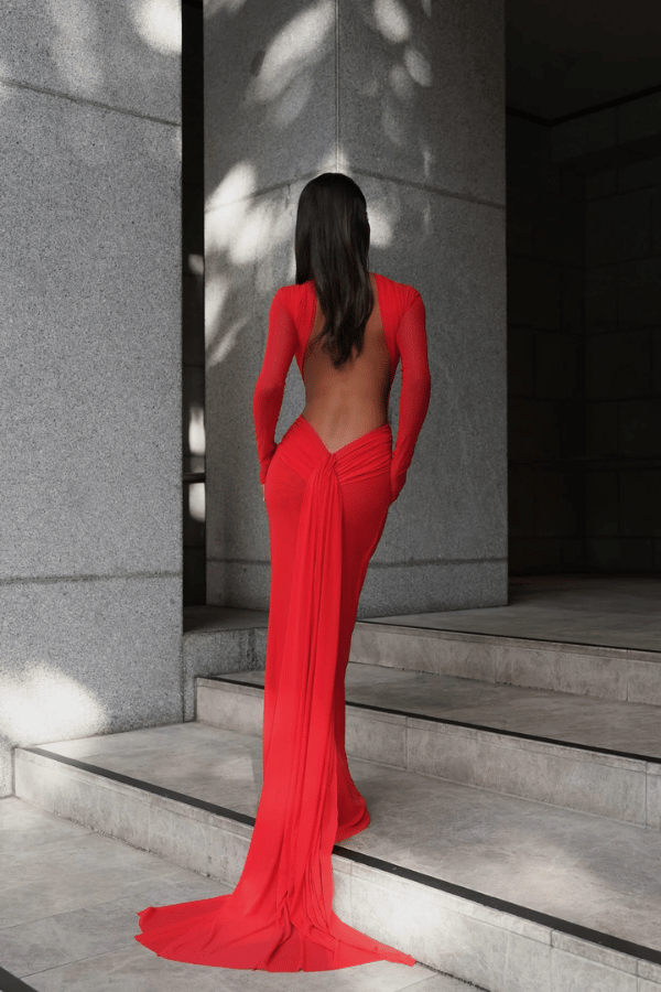 Monaco Gown Red by Effie Kats – Elegant soft mesh gown with high neckline, long sleeves, and daring open back, featuring ruching and crossed waist for a sculpted, timeless silhouette.