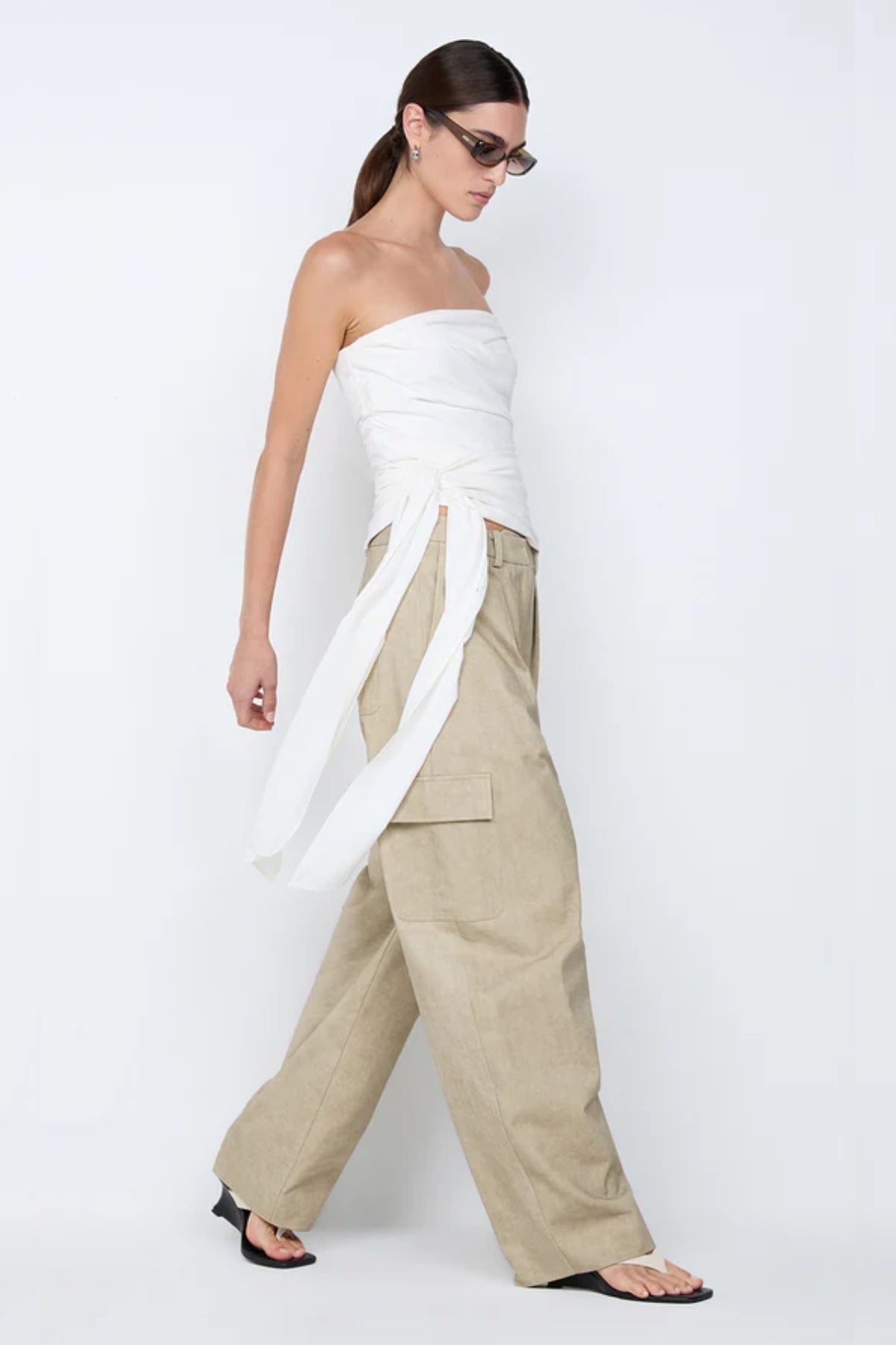 Belle Strapless Top by Bec + Bridge, a sleek nylon silhouette with tucked bodice and front tie detail—perfect for bridal or resort occasions.