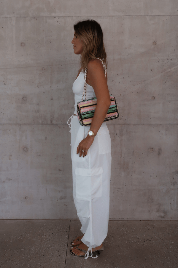 Bella Halter Tank White by Sneaky Link – Soft cotton-spandex blend with a deep scoop neckline, open back, and supportive halter design. Perfect for layering or solo wear.