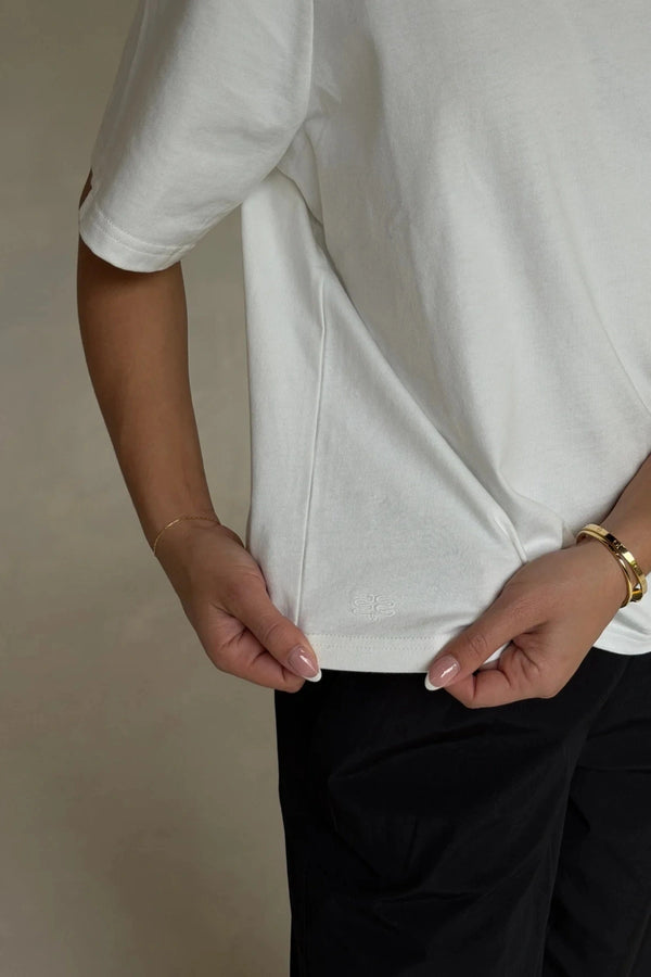 White Olivia High V Neck Relaxed Tee with short sleeves and a loose fit on a plain background.
