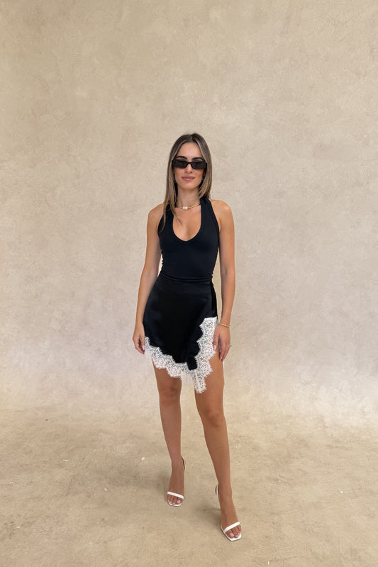 Lilah Lace Trim Mini Skirt by Sneaky Link – an asymmetrical mini with contrast lace detail. Perfect for elevated day-to-night styling.