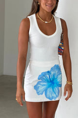 Chiara Mini Skirt White Hibiscus by Sneaky Link, a cotton A-line mini skirt with bold blue hibiscus print for summer styling.
