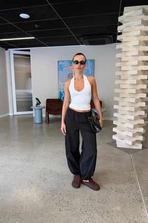 Black mid-rise balloon pants with a relaxed fit and tapered ankles, styled on a model against a plain background.