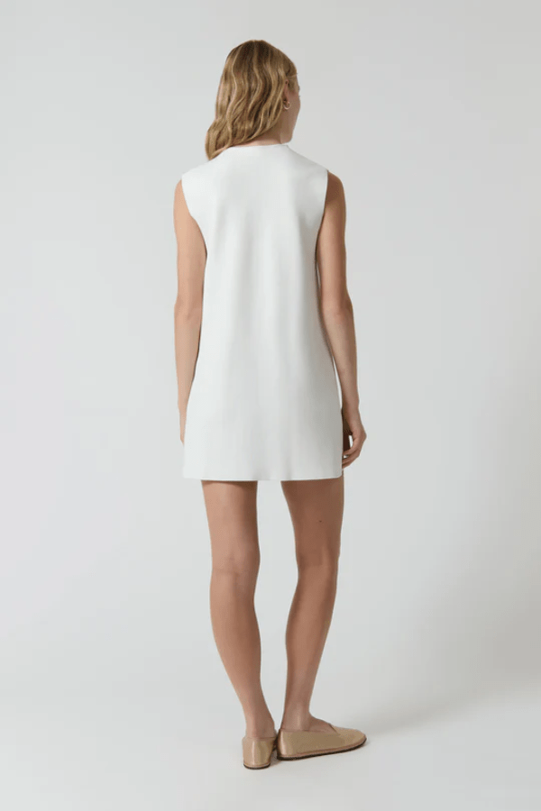 Nanda Dress White by Onte – A chic, timeless sleeveless mini shift in heavy Milano knit with gold knot buttons and welt pockets, perfect for effortless day-to-night style.