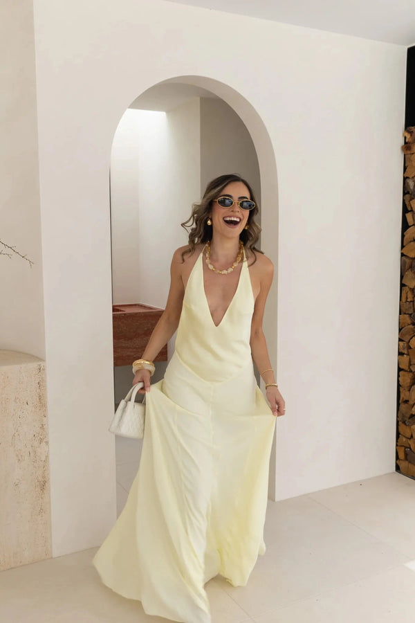 Jaz Hand V-Neck Maxi Dress in Butter by Sneaky Link, a flowing one-shoulder silhouette in soft yellow. Perfect for summer events or weddings.
