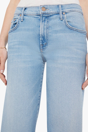 The Mid Rise Maven Sneak Jeans in Blowing In The Wind by MOTHER, wide-leg silhouette with rose gold hardware and contrast stitching. Perfect for elevated casual styling.
