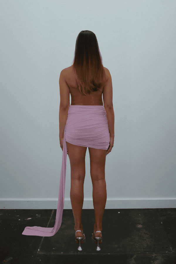 Tiffany Dress Baby Pink by DŽO – Trendy rhinestone-embellished sheer mesh mini with draped cowl neckline, ruched skirt, and dramatic side train, perfect for glamorous evening occasions.