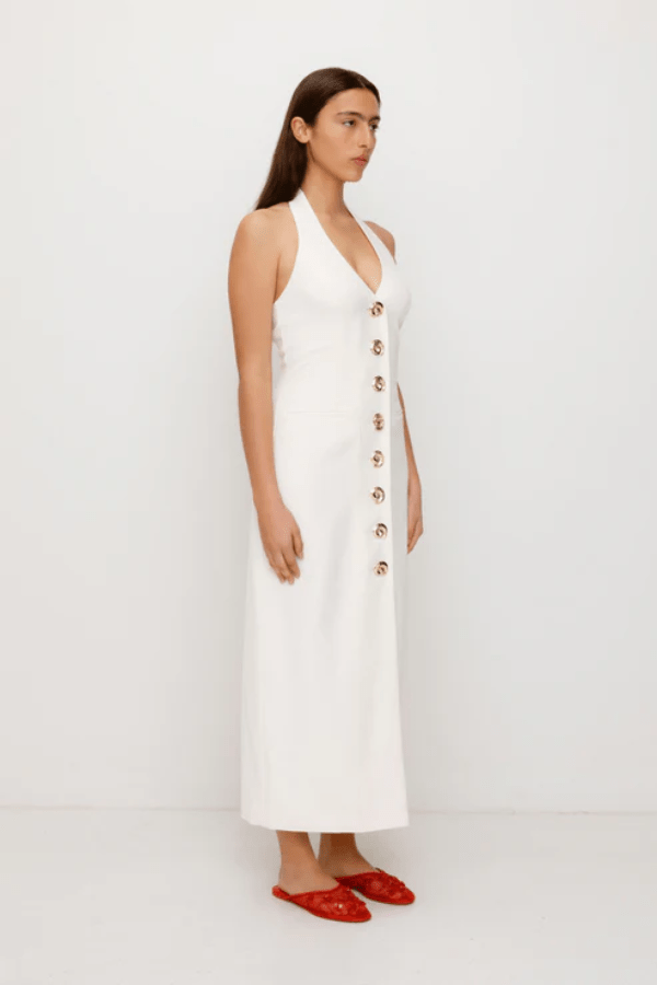 Irida Maxi Dress Ivory by The Wolf Gang – A trendy fitted maxi with halter neckline and gold swirl details, perfect for timeless elegance at special occasions.