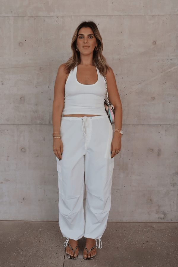 Bella Halter Tank White by Sneaky Link – Soft cotton-spandex blend with a deep scoop neckline, open back, and supportive halter design. Perfect for layering or solo wear.