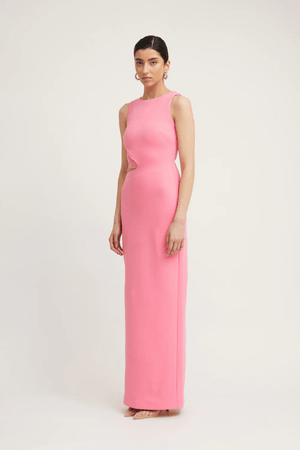 Valentina Dress Rouge Pink by Tojhà – A bold and sleek maxi with a boat neckline and unique waist cut-out, perfect for elegant evenings and special events.