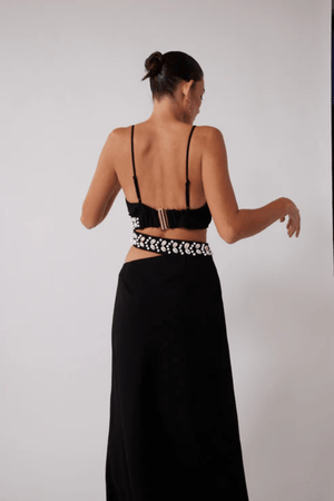 La Playa Maxi Dress Noir by The Wolf Gang – Maxi dress with cowrie shell cutouts, adjustable tie, and luxe gold clasp closure.