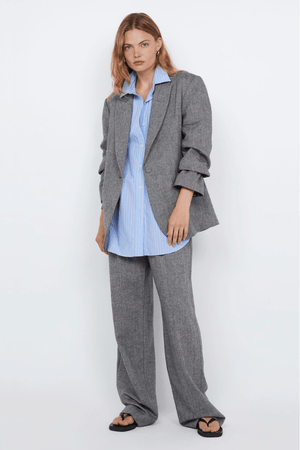 Brinley Blazer Salt & Pepper Weave by Bec + Bridge – Tailored single-breasted blazer in heavy wool blend with self-covered buttons, shoulder pads, boxy fit, and back vent. Fully lined.