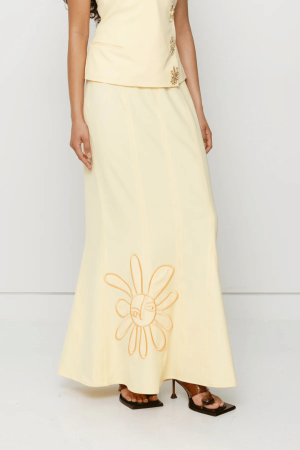Inka Maxi Skirt Butter by The Wolf Gang, a flared godet midi with custom embroidery. Perfect for standout sets or sunny solo moments.