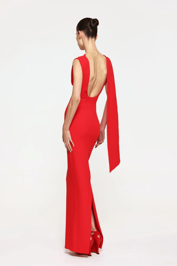 Audrey Gown Cherry Red by Effie Kats – A chic stretch crepe gown with a straight neckline, exaggerated low back, and elegant over-the-shoulder detail, perfect for special occasions.