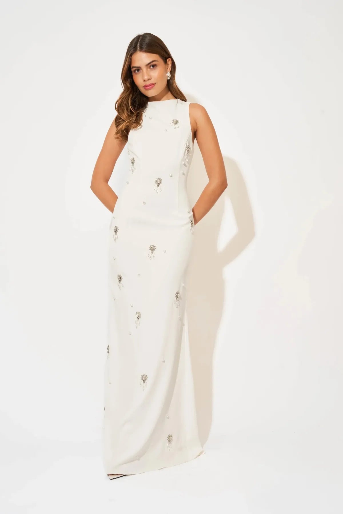 Crystal Maxi Dress by Odd Muse, a white bridal maxi with crystal and pearl detailing, high neckline and elegant fitted silhouette.
