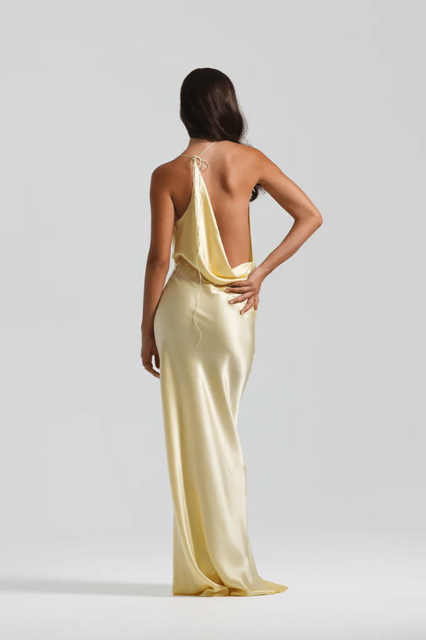Gabi Gown Lemon by Natalie Rolt – A trendy bias-cut silk gown with an elegant asymmetric silhouette, open back, and delicate ties, perfect for special occasions.