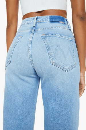 The Lasso Sneak Sow Surreal by MOTHER, trendy super high-rise wide-leg jeans with a light blue wash, whiskering, and fading. Perfect for a vintage-inspired look with a clean hem and structured fit.