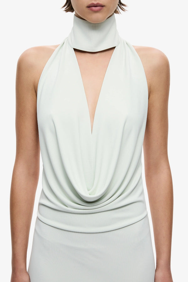 The Cowl Neck Jersey Dress by MISHA, halter cowl maxi with open back and side split for sleek evening styling.