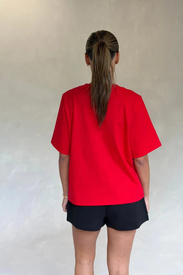 Red Olivia High V Neck Relaxed Tee with short sleeves and a loose fit on a plain background.