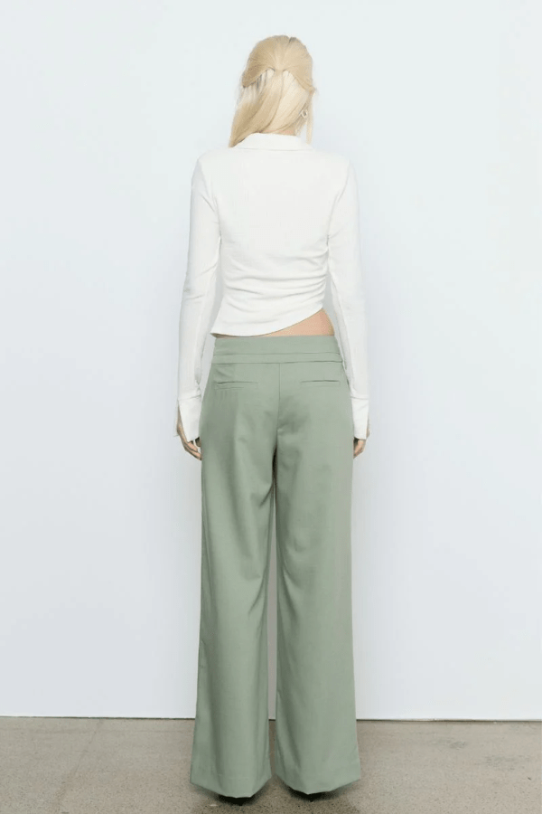 Emile Top White by Sovere — A fitted long-sleeve top in textured stretch fabric featuring a fixed wrap front, structured collar, wide split cuffs, and side gathers for a flattering silhouette. Fully lined for smooth wear and effortless sophistication.