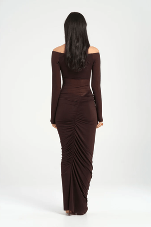Wilma Maxi Dress Chocolate by Benni, featuring an off-shoulder V-neckline, full-length sleeves, sheer waist, and asymmetrical drape for a sculpted silhouette. Ideal for statement evenings.