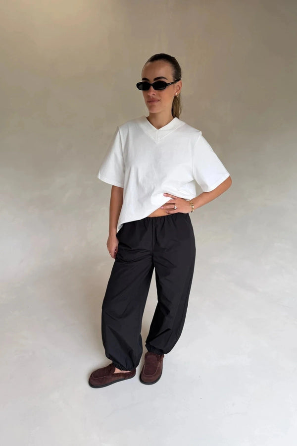 Black mid-rise balloon pants with a relaxed fit and tapered ankles, styled on a model against a plain background.
