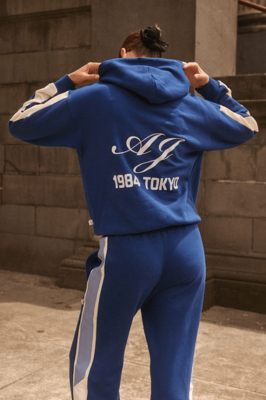 1985 Hoodie Estate Blue by Araminta James, soft cotton brushed fleece with contrast trim and velvet graphic, relaxed fit perfect for casual cool days.