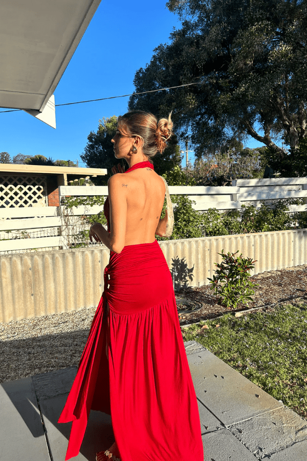 Dakota Pure Red by Deconduarte – Trendy fluid jersey dress with elastic neckline, fitted belt skirt, side slit, and lettuce-edge hem, perfect for confident, carefree occasions.