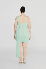 Hilván Mini Dress Salvia by Maygel Coronel – A trendy, sculptural mini with asymmetric neckline, 3D floral strap, ruched bodice, and flowing back sash. Perfect for modern, elegant nights out.