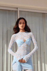 Ortigia Baby Blue by Decon Duarte – A trendy sheer stretch lace dress in soft powder blue, featuring a backless design and adjustable mini skirt. Perfect for year-round stylish occasions.