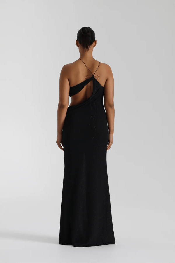 Elissa Dress Black by Natalie Rolt – A glamorous stretch-knit maxi with metallic threads, asymmetrical cutaway, and adjustable fit, perfect for elegant evenings and special occasions.