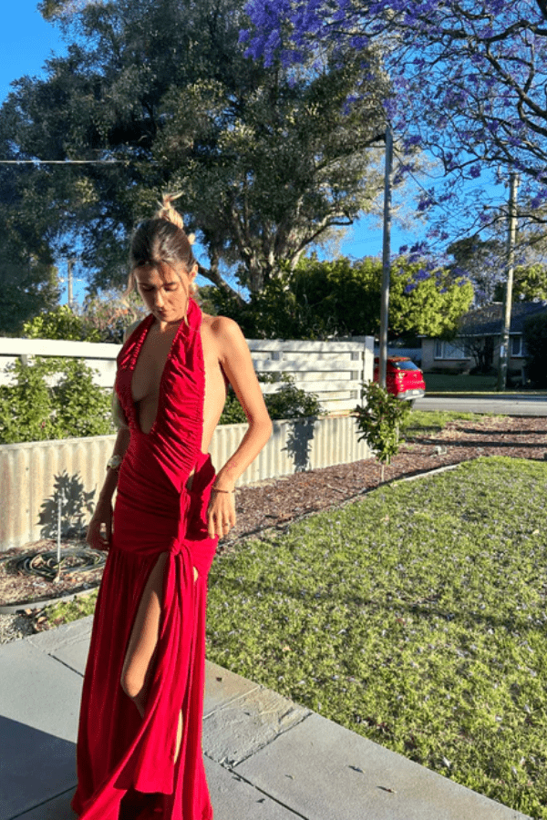 Dakota Pure Red by Deconduarte – Trendy fluid jersey dress with elastic neckline, fitted belt skirt, side slit, and lettuce-edge hem, perfect for confident, carefree occasions.