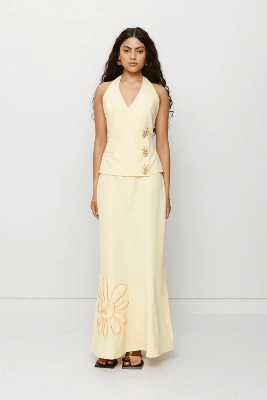 Inka Maxi Skirt Butter by The Wolf Gang, a flared godet midi with custom embroidery. Perfect for standout sets or sunny solo moments.
