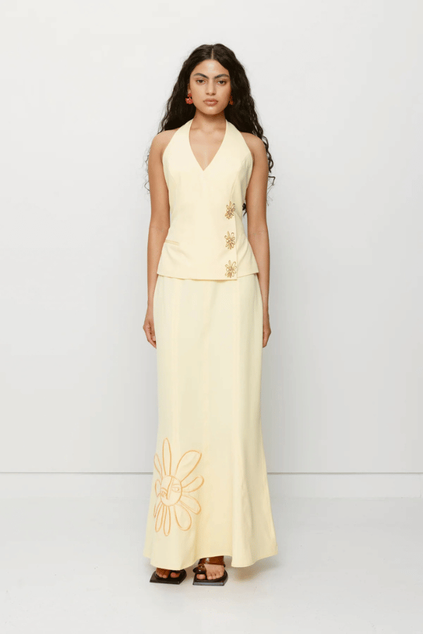 Inka Maxi Skirt Butter by The Wolf Gang, a flared godet midi with custom embroidery. Perfect for standout sets or sunny solo moments.