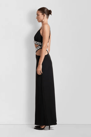 La Playa Maxi Dress Noir by The Wolf Gang – Maxi dress with cowrie shell cutouts, adjustable tie, and luxe gold clasp closure.