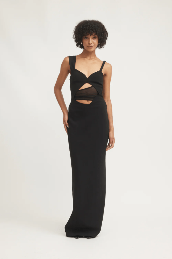 Madeleine Dress Black by Tojhà – A viral double-bonded crepe maxi with asymmetric straps, curved cut-out, and layered mesh, perfect for elegant evening events.