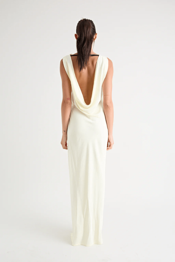 Matia Gown Butter by Pfeiffer – A timeless maxi with a boat neckline, low back, and adjustable strap. Perfect for elegant events and special occasions.