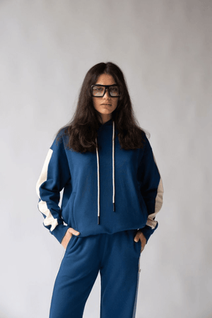 1984 Hoodie Estate Blue by Araminta James, soft cotton brushed fleece with contrast trim and velvet graphic, relaxed fit perfect for casual cool days.