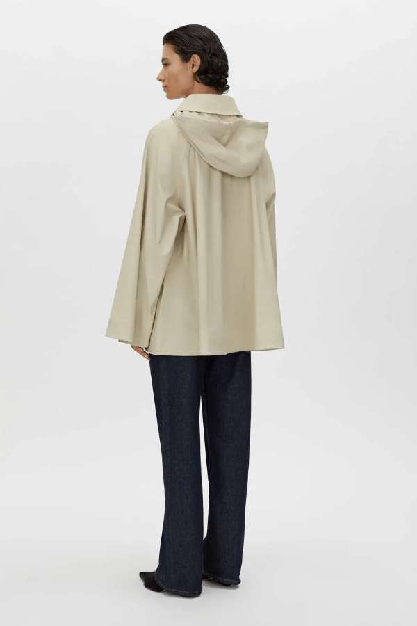 Memento Raincoat Alabaster by Camilla and Marc – double-breasted with hood and monogram detail, perfect for stylish rainy days or light layering.