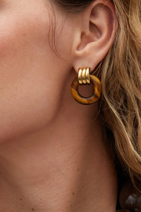 Luma Knot Earrings Gold/Tiger’s Eye by Heaven Mayhem, 18k gold PVD-plated knot earrings with natural Tiger’s Eye stone.