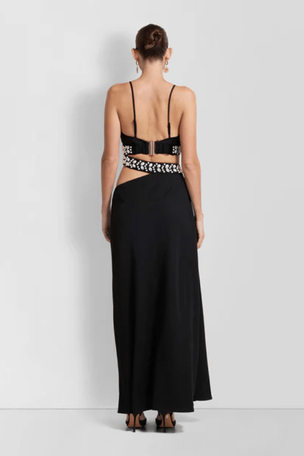 La Playa Maxi Dress Noir by The Wolf Gang – Maxi dress with cowrie shell cutouts, adjustable tie, and luxe gold clasp closure.