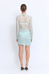 Vero Lace Dress Mint by Pfeiffer – A sheer lace mini with full sleeves and a decorative tail, perfect as a beach cover-up, vacation statement, or summer night-out essential.