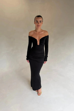 Black Haley off-shoulder midi dress with fitted bodice and flowy skirt, featuring short sleeves and a subtle slit.