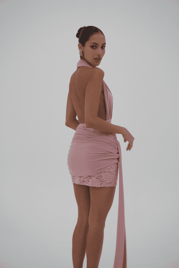 Chrissy Pink by Deconduarte – Trendy two-piece stretch lace set with fitted dress, dramatic over-belt skirt, and daring open back, perfect for bold, elegant formal events.