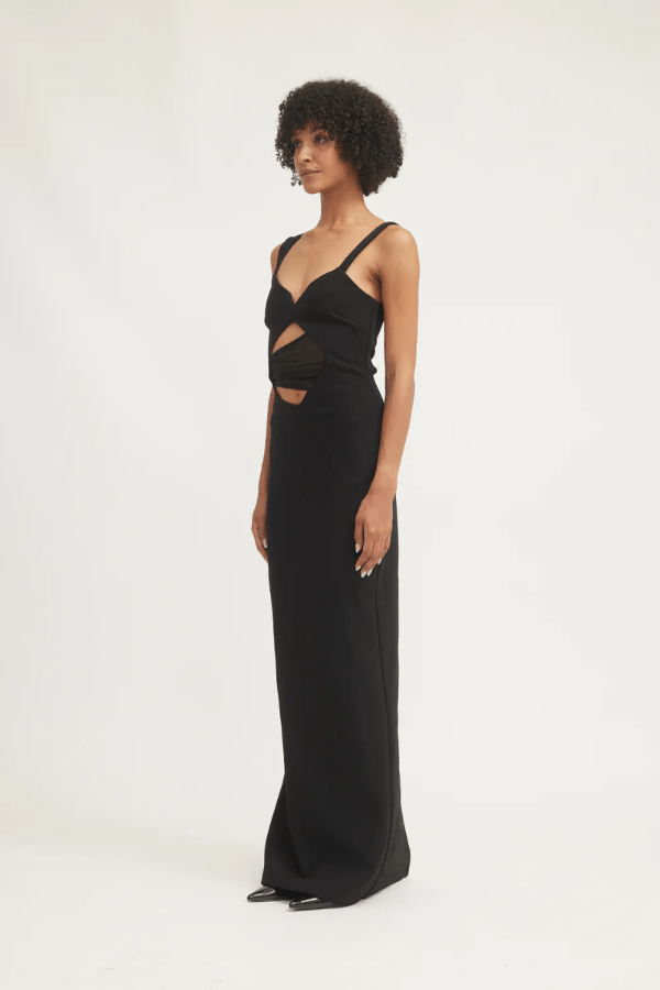 Madeleine Dress Black by Tojhà – A viral double-bonded crepe maxi with asymmetric straps, curved cut-out, and layered mesh, perfect for elegant evening events.