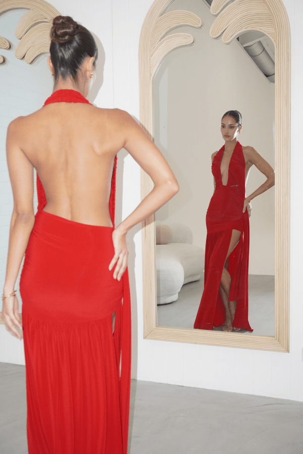 Dakota Pure Red by Deconduarte – Trendy fluid jersey dress with elastic neckline, fitted belt skirt, side slit, and lettuce-edge hem, perfect for confident, carefree occasions.