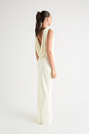 Matia Gown Butter by Pfeiffer – A timeless maxi with a boat neckline, low back, and adjustable strap. Perfect for elegant events and special occasions.