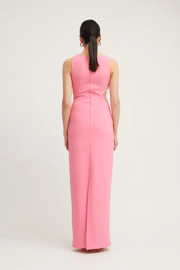 Valentina Dress Rouge Pink by Tojhà – A bold and sleek maxi with a boat neckline and unique waist cut-out, perfect for elegant evenings and special events.