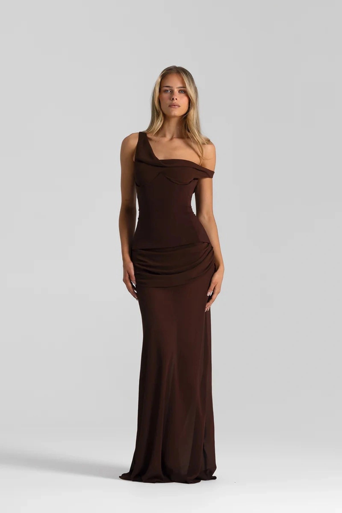 Cadence Dress Espresso by Natalie Rolt – a draped off-shoulder gown with a removable corset for shaping. Perfect for elegant events.