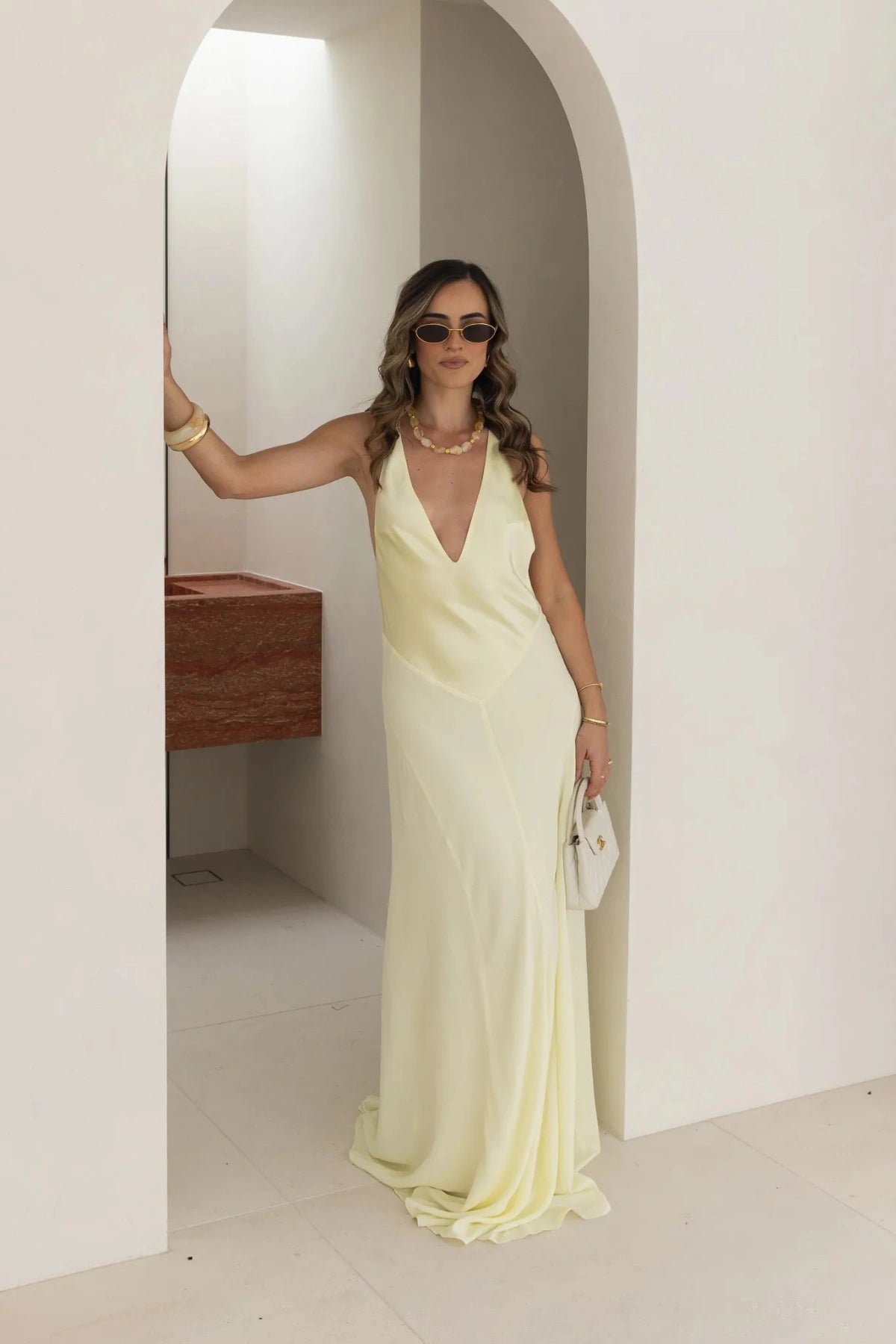 Jaz Hand V-Neck Maxi Dress in Butter by Sneaky Link, a flowing one-shoulder silhouette in soft yellow. Perfect for summer events or weddings.
